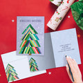 Load image into Gallery viewer, The inside of Tree-Free’s Navidenas Tree card, with the cover and envelope in the background.