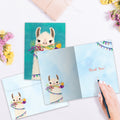 Load image into Gallery viewer, The inside of Tree-Free’s Amazing Llama card, with the cover and envelope in the background.