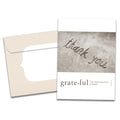 Load image into Gallery viewer, Cover of Grateful Thank You card (featuring serif text underneath a photograph of the phrase "thank you" written in sand) and its matching envelope