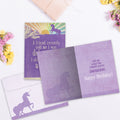 Load image into Gallery viewer, The inside of Tree-Free’s Fell Off Unicorn card, with the cover and envelope in the background.