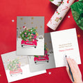 Load image into Gallery viewer, The inside of Tree-Free’s Headed Home Christmas Card card, with the cover and envelope in the background.