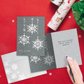 Load image into Gallery viewer, The inside of Tree-Free’s Silver And Gold Christmas card, with the cover and envelope in the background.