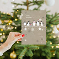 Load image into Gallery viewer, Lifestyle image(s) featuring Tree-Free's Balancing Penguins Christmas Card card