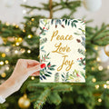 Load image into Gallery viewer, Lifestyle image(s) featuring Tree-Free's Peace Joy Watercolor Holiday Card card