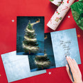 Load image into Gallery viewer, The inside of Tree-Free’s Magical Reindeer card, with the cover and envelope in the background.