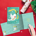Load image into Gallery viewer, The inside of Tree-Free’s Peace Dove Holiday Card card, with the cover and envelope in the background.