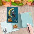 Load image into Gallery viewer, The inside of Tree-Free’s Black Cat And Moon Halloween Card card, with the cover and envelope in the background.