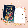 Load image into Gallery viewer, The inside of Tree-Free’s Floating Lights New Year Card card, with the cover and envelope in the background.