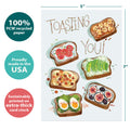 Load image into Gallery viewer, The cover of Tree-Free’s Toasting You card with lines demonstrating its 5x7 dimensions, along with the following text: “100% PCW recycled paper, proudly made in the USA, sustainably printed on extra-thick card stock”