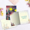 Load image into Gallery viewer, The inside of Tree-Free’s Animal Serenade Birthday card, with the cover and envelope in the background, surrounded by flowers and a wrapped gift. The card inside features a smaller image of the forest animals in the lower left corner and elements of the painted sunset throughout.