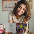 Load image into Gallery viewer, A woman holding Tree-Free’s Animal Serenade card and smiling
