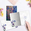 Load image into Gallery viewer, The inside of Tree-Free’s Thoughtful Irises card, with the cover and envelope in the background.