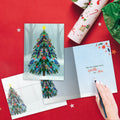 Load image into Gallery viewer, The inside of Tree-Free’s Tree Sparkle card, with the cover and envelope in the background.