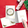 Load image into Gallery viewer, The inside of Tree-Free’s Winter Pine Wreath card, with the cover and envelope in the background.