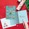Load image into Gallery viewer, The inside of Tree-Free’s Meowy Christmas card, with the cover and envelope in the background.