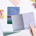 Load image into Gallery viewer, The inside of Tree-Free’s Sunset Dawn card, with the cover and envelope in the background.
