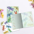Load image into Gallery viewer, The inside of Tree-Free’s Dragonflies card, with the cover and envelope in the background.