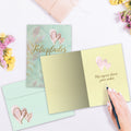Load image into Gallery viewer, The inside of Tree-Free’s Felicidades Hearts card, with the cover and envelope in the background.