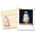 Load image into Gallery viewer, Cover of Love and Happiness Wedding card (featuring serif text below artwork of a cake on a stand surrounded by flowers, hearts, and stars) and its matching envelope