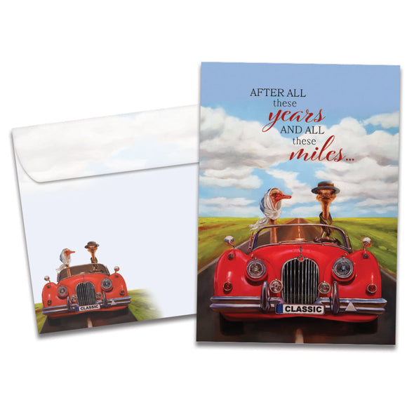 Cover of All These Miles Anniversary card (featuring script and serif text above artwork of two ostriches driving a car down a country road) and its matching envelope