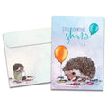 Load image into Gallery viewer, Cover of Still Looking Sharp Birthday card (featuring script and serif text above artwork of a hedgehog surrounded by popped and unpopped balloons) and its matching envelope
