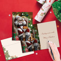 Load image into Gallery viewer, The inside of Tree-Free’s Cat Nap Santa Christmas Card card, with the cover and envelope in the background.
