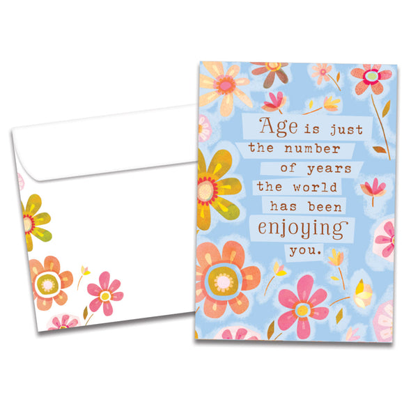 Cover of The World Enjoys You Birthday card (featuring script and serif text surrounded by artwork of flowers) and its matching envelope