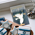 Load image into Gallery viewer, The inside of Tree-Free’s Peace Dove Menorah Hanukkah Card card, with the cover and envelope in the background.
