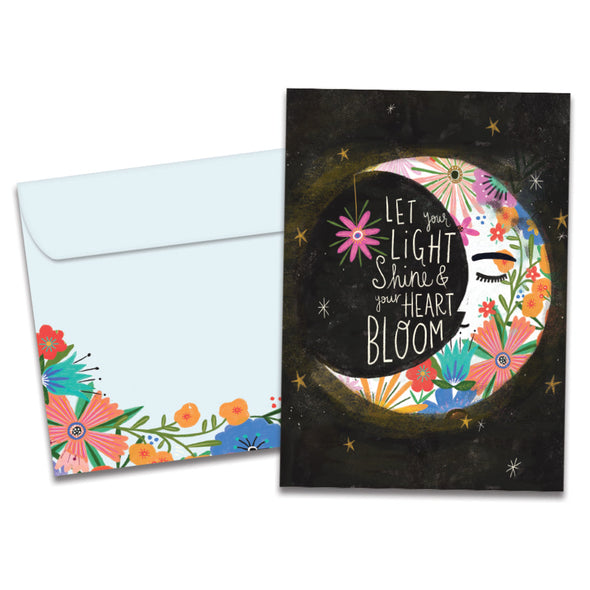 Cover of Let Light Shine Birthday card (featuring script text above artwork of the moon wearing a crown of flowers) and its matching envelope