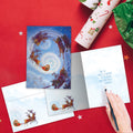 Load image into Gallery viewer, The inside of Tree-Free’s Soaring Santa card, with the cover and envelope in the background.

